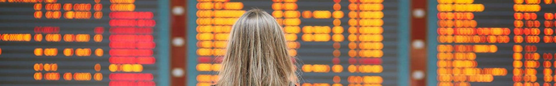 Women at indicator board - visiting the UK